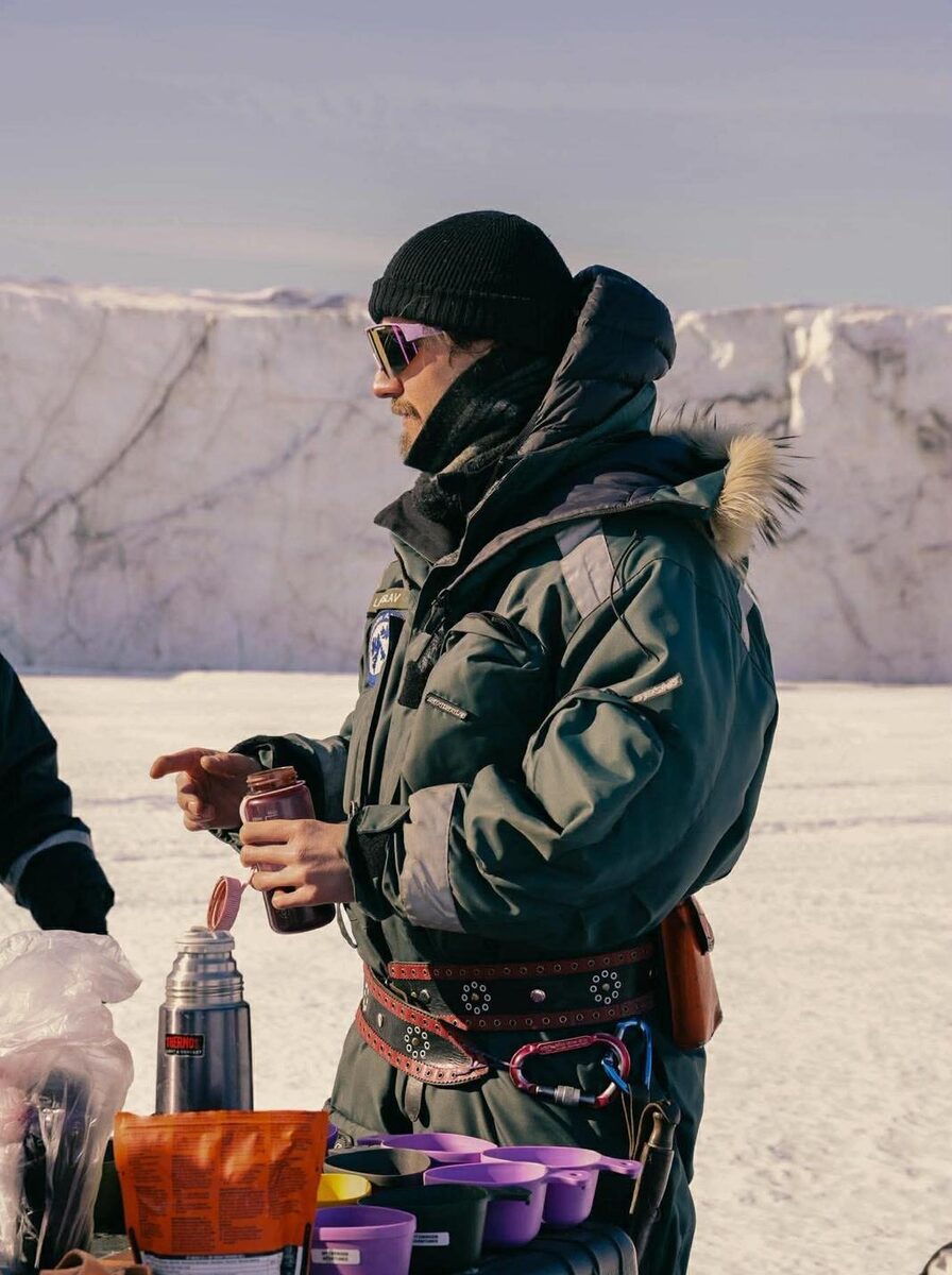 Lad in winter gear on the ice with a thermos